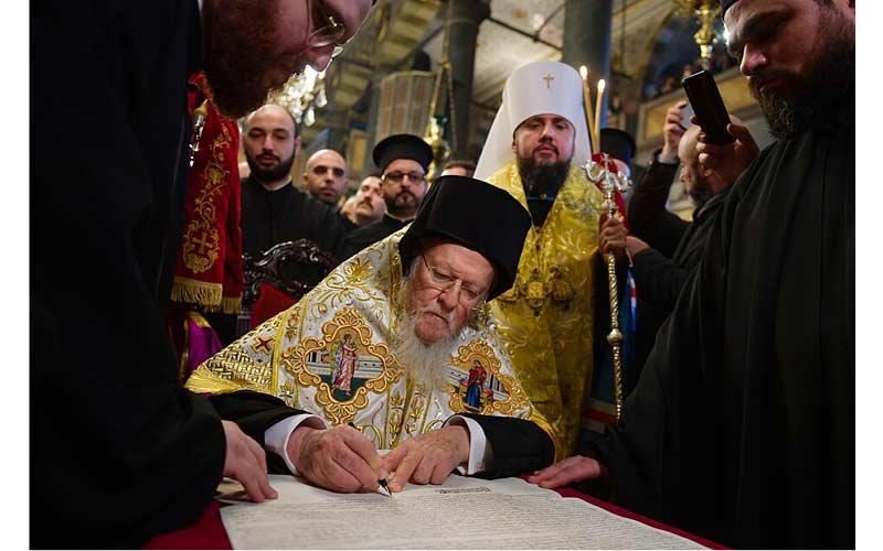 Патријарх Вартоломеј потписује томос о аутокефалности ПЦУ. Иза њега стоји кијевски "митрополит" "Епифаније" (са белим клобуком).