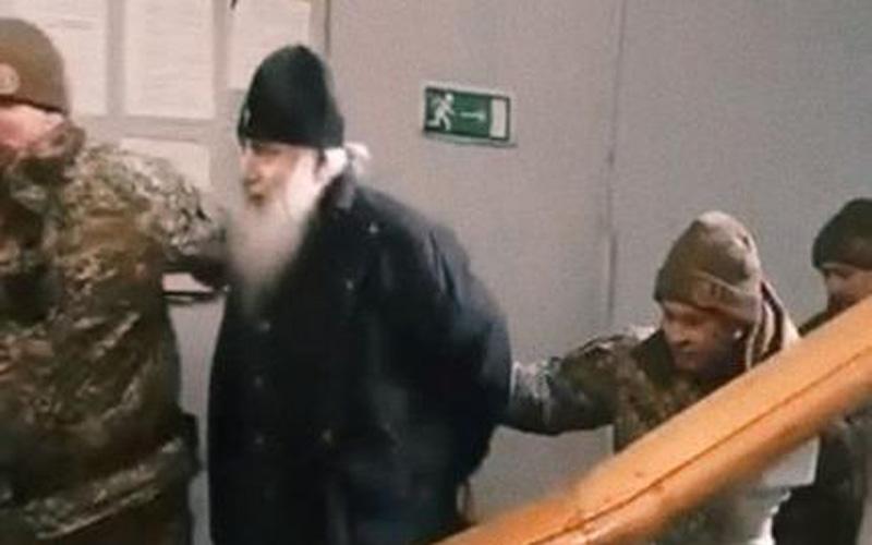 митрополита Арсенија спроводе са лисицама на рукама четворица 